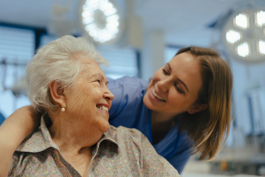 Portrait of nurse and senior patient talking in hospital corridor. Emotional support for elderly